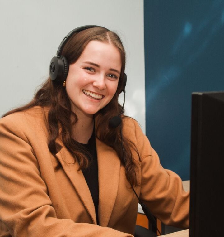 A sales consultant with a headset at her desk