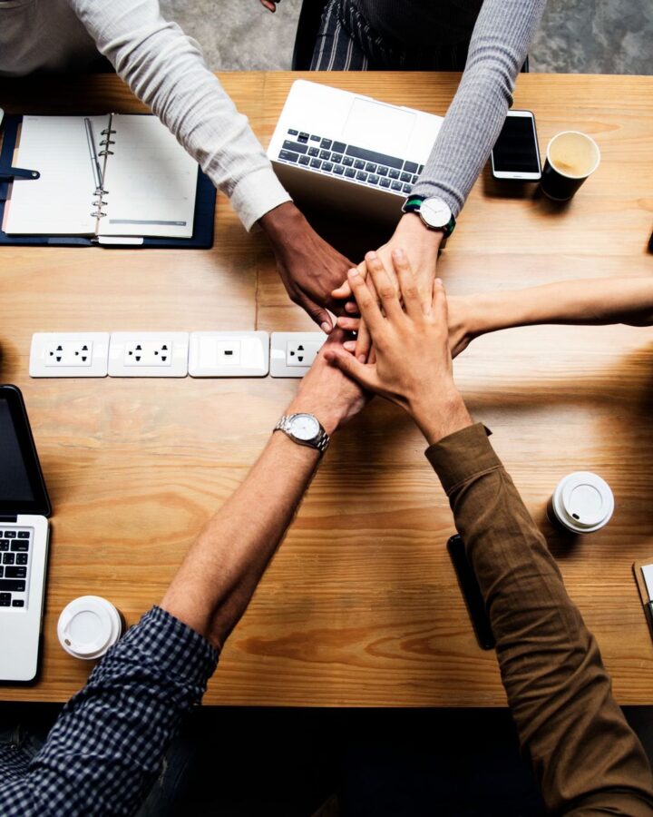 A team stacking hands over a desk